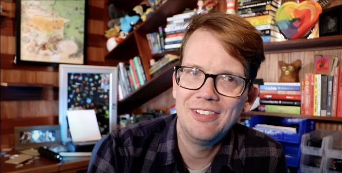 A closeup of Hank Green sitting in what looks to be an office