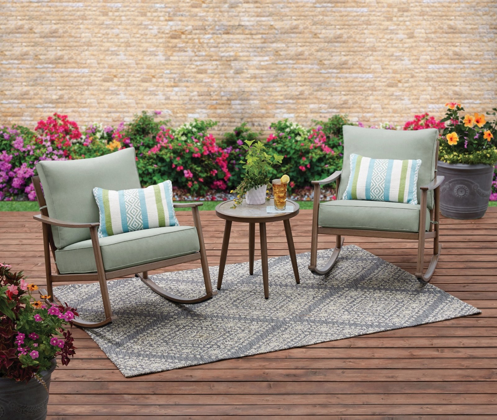 the light green cushioned rocking chairs with a small brown side table in a decorated patio space