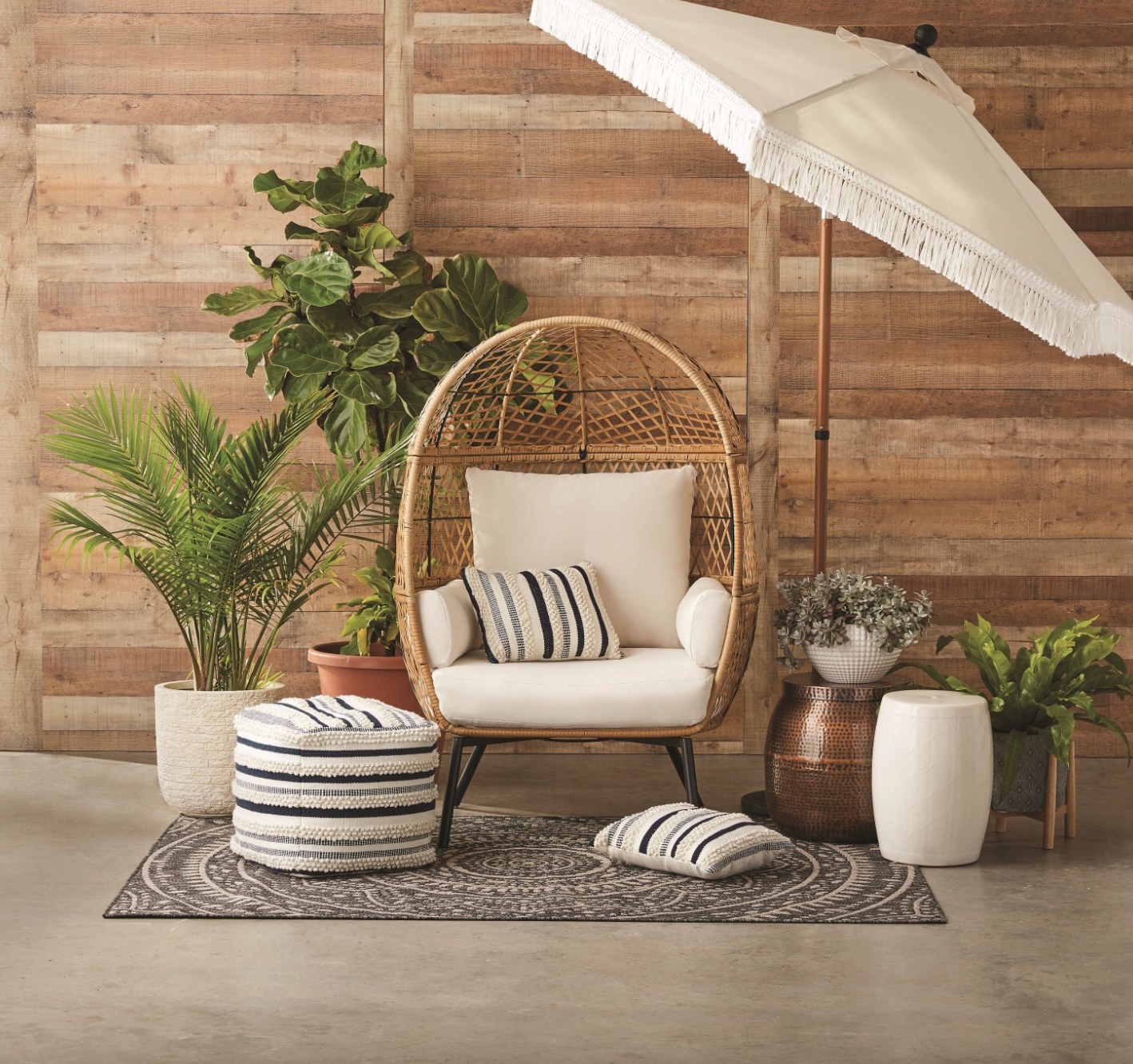 the tan rattan chair with white cushions in a decorated patio space