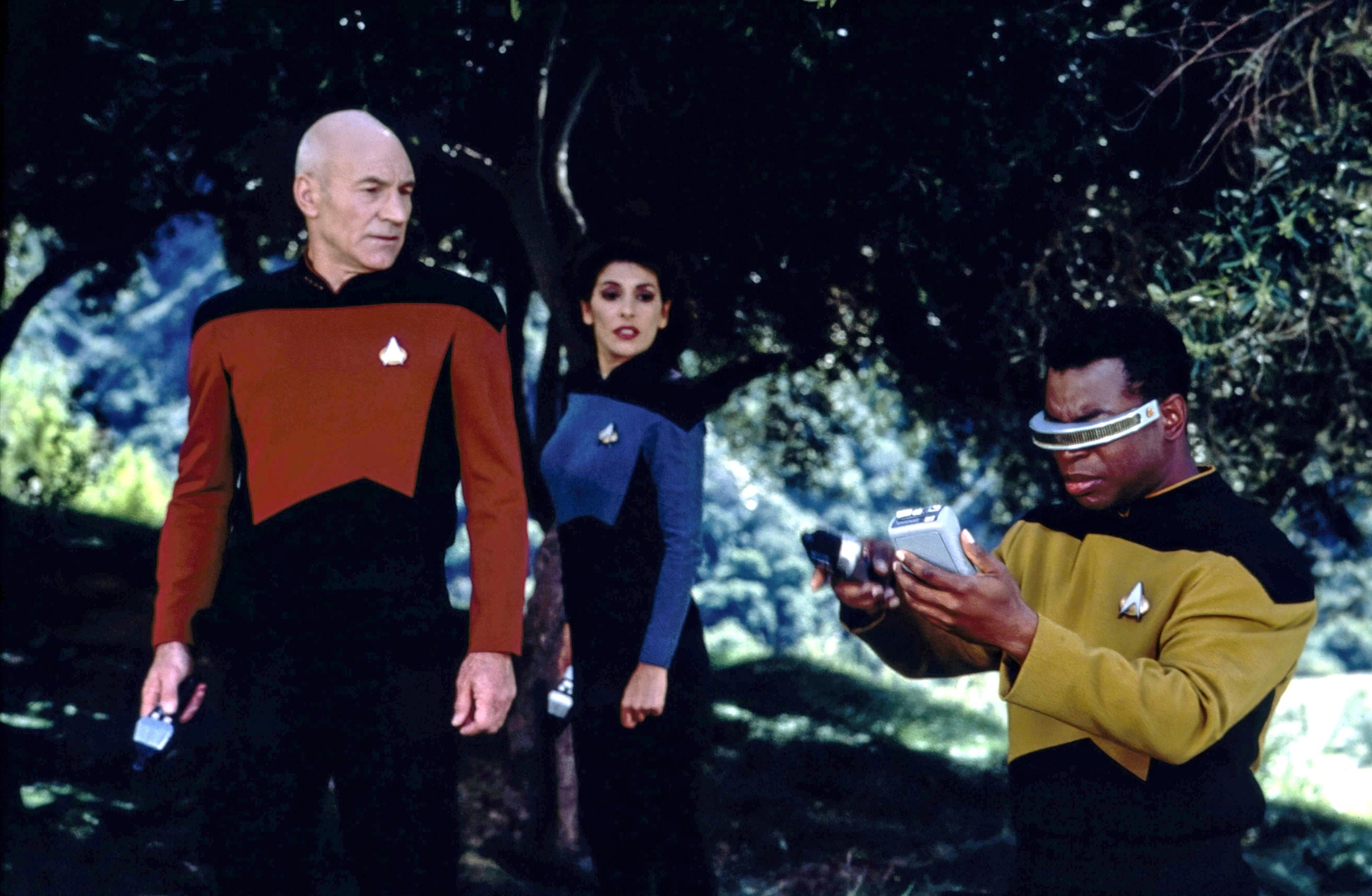 Picard, Lieutenant Commander Troi, and Lieutenant Commander Geordi La Forge work to figure out a problem on the ship