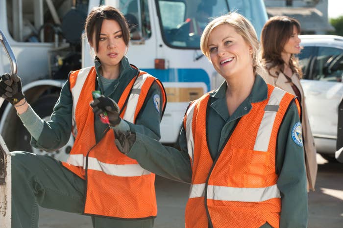 Leslie smiles while April looks in disgust in "Parks and Rec"