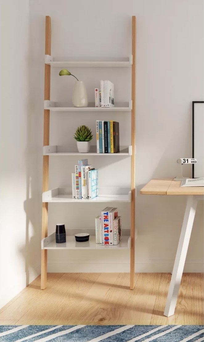 the wood and white ladder bookshelf in a home office