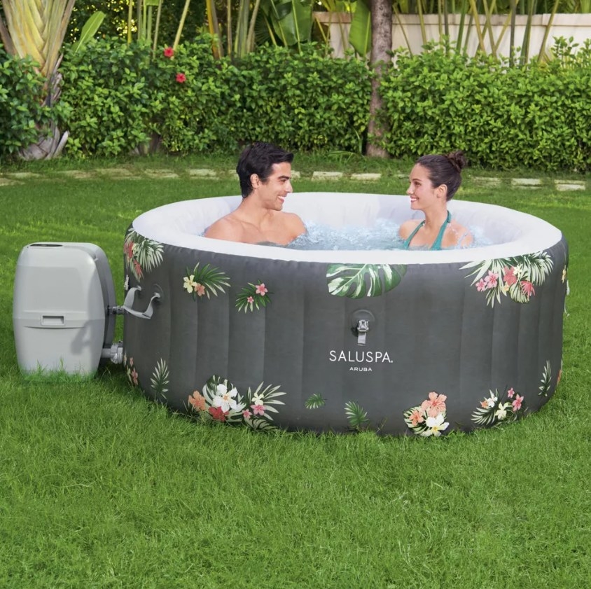 The Aruba hot tub with two people sitting inside it