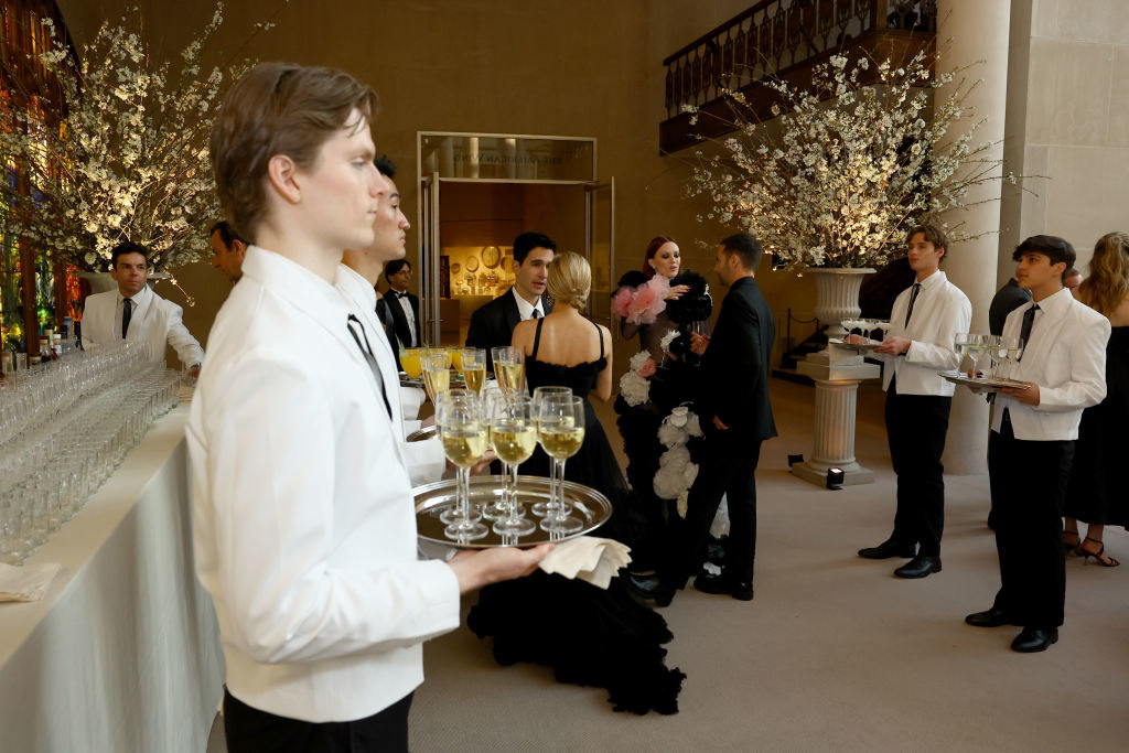 Waiters with cocktails as guests enter