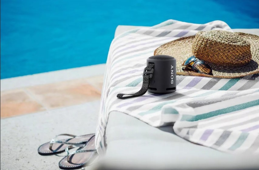 The portable speaker on a deckchair by the pool