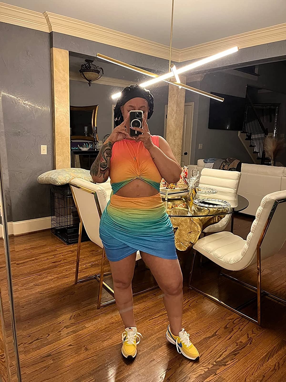 reviewer wearing rainbow sleeveless bodycon dress with cutout design