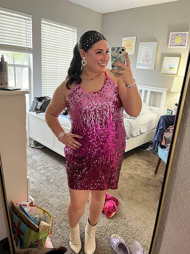reviewer wearing sleeveless sparkly pinkish  sequin formal  with achromatic  boots