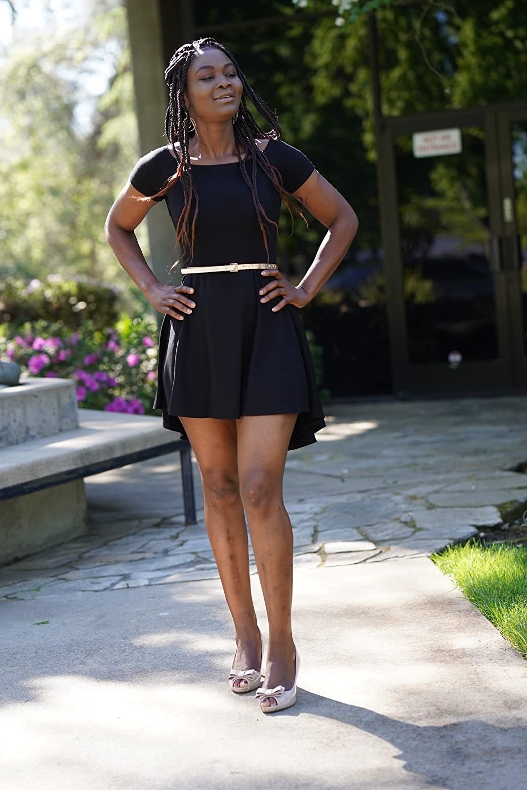 reviewer wearing the black high-low cocktail dress with white heels