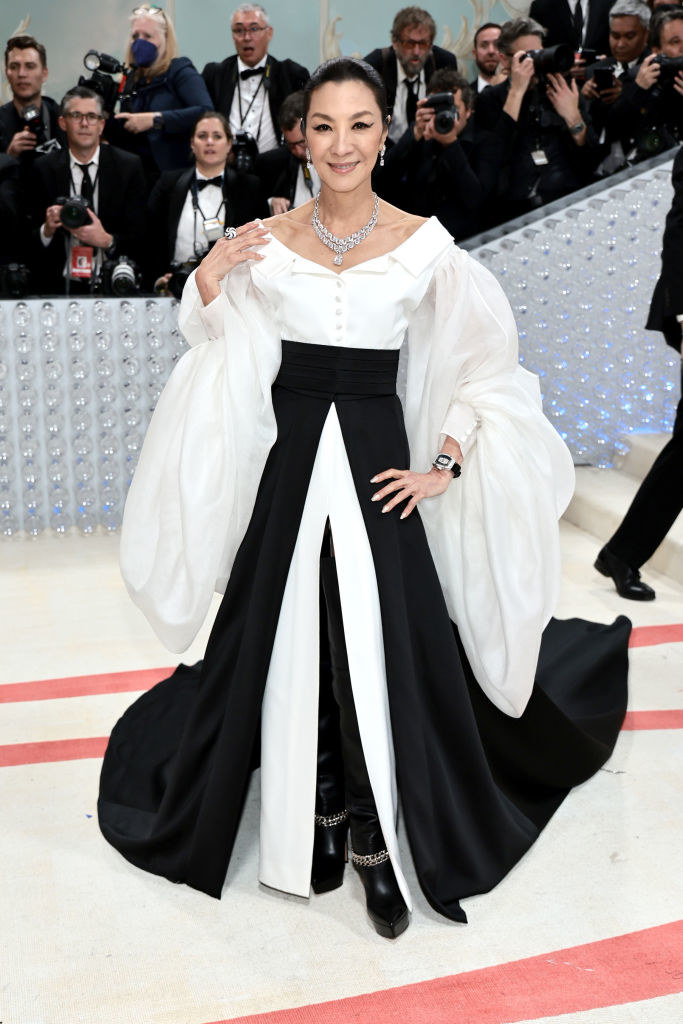 wearing a long gown with puffy exaggerated sleeves