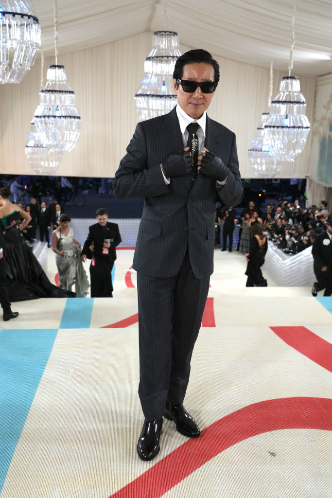 wearing a suit with karl lagerfeld style cut out gloves