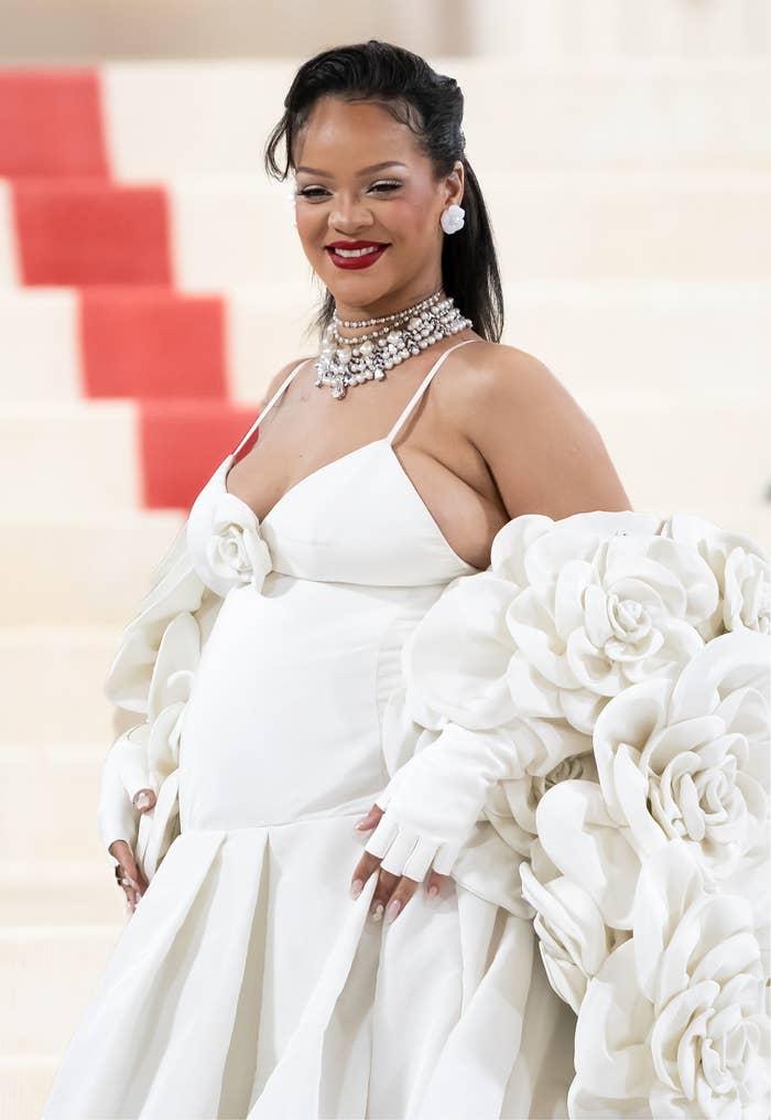 Rihanna in a white dress and a coat with large camellias