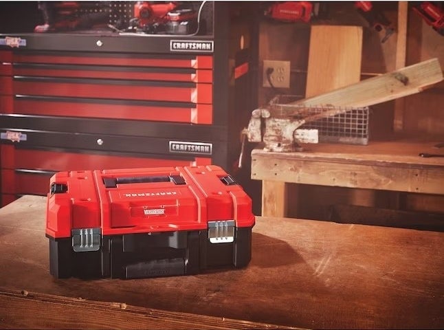 A red toolbox holder in a room with wood