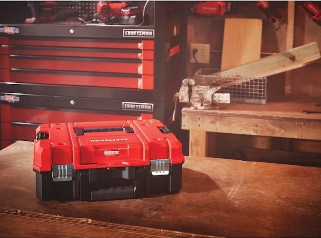 A red toolbox holder in a room with wood