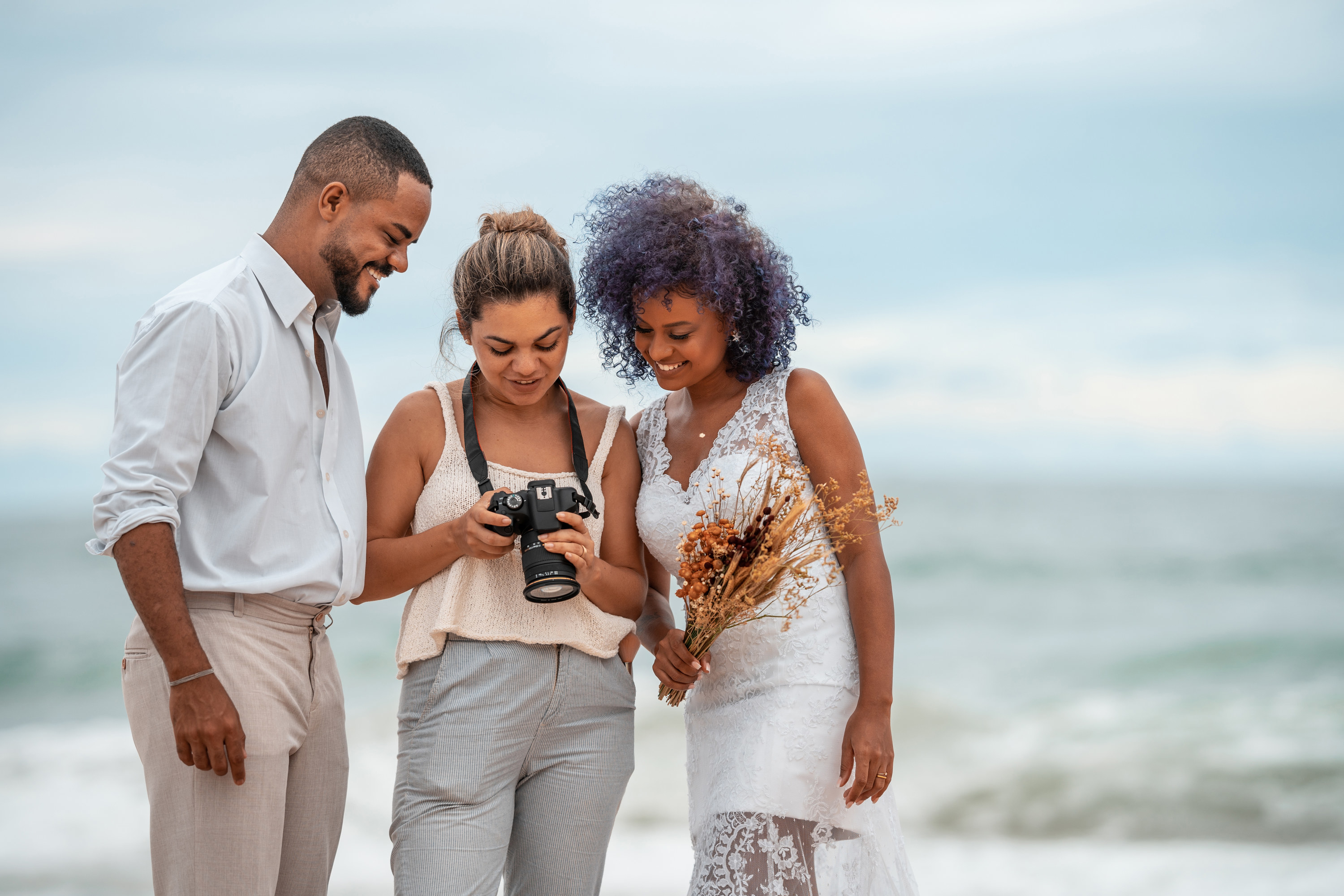 A photographer showing a bride and groom photos on her camera