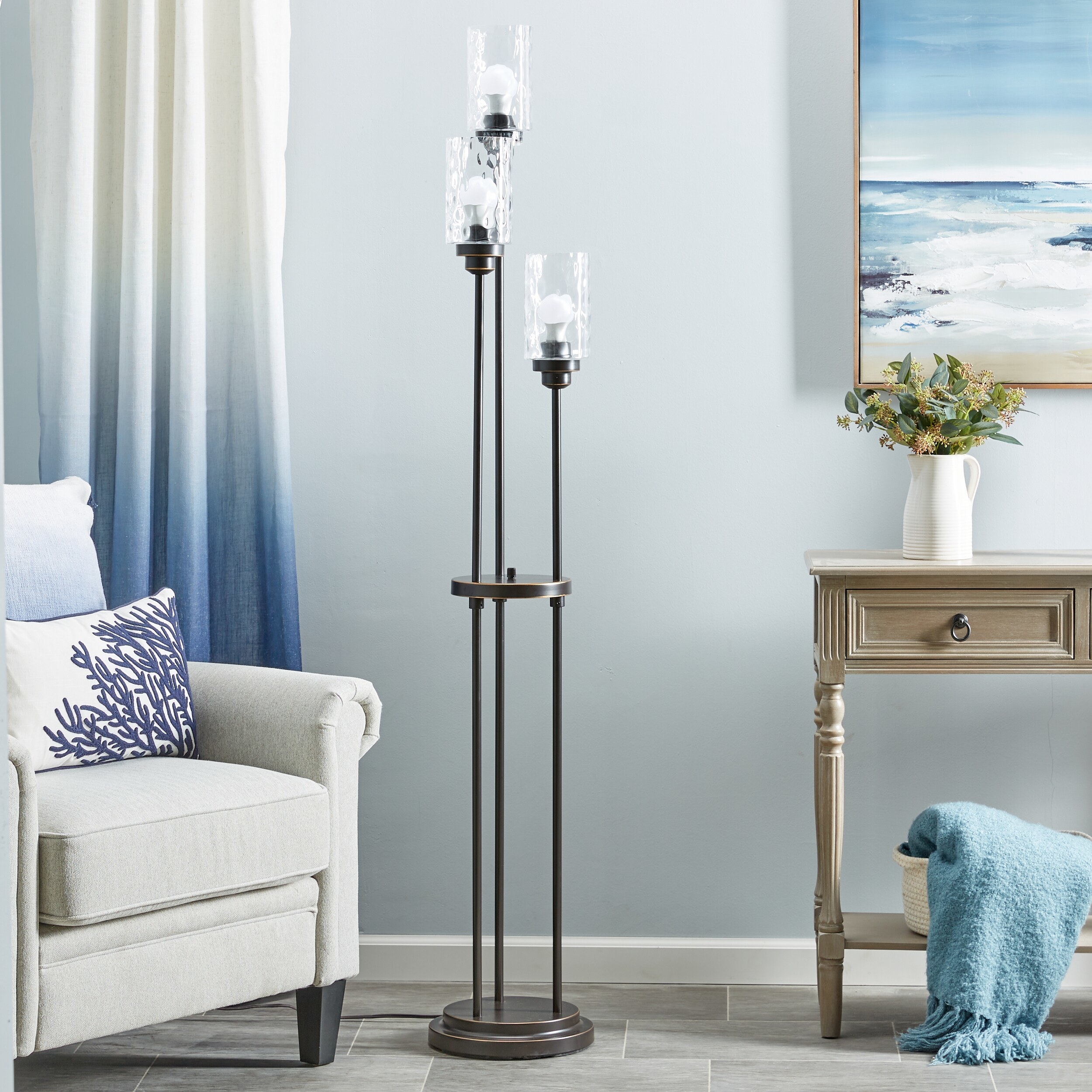A bronze lamp with three lights in a blue living room