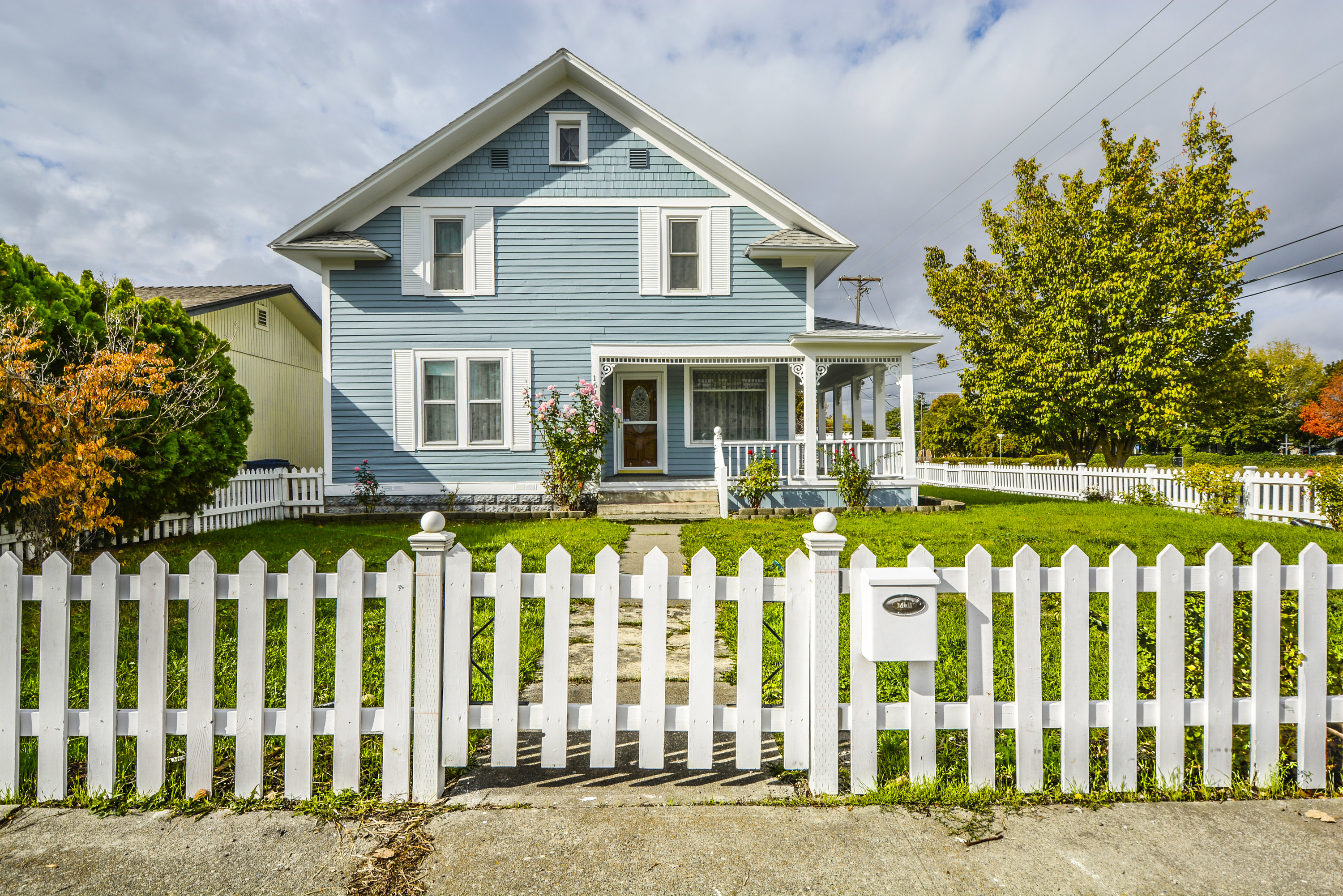 a victorian house with a white picket fence surrounding it