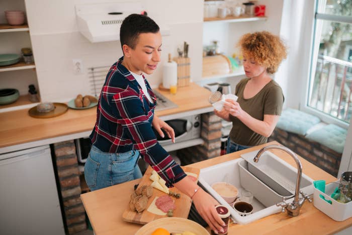 a couple in the kitchen doing chores