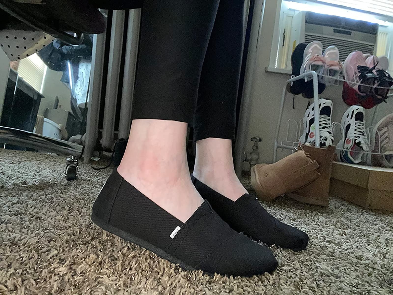 reviewer wearing black Toms canvas loafers