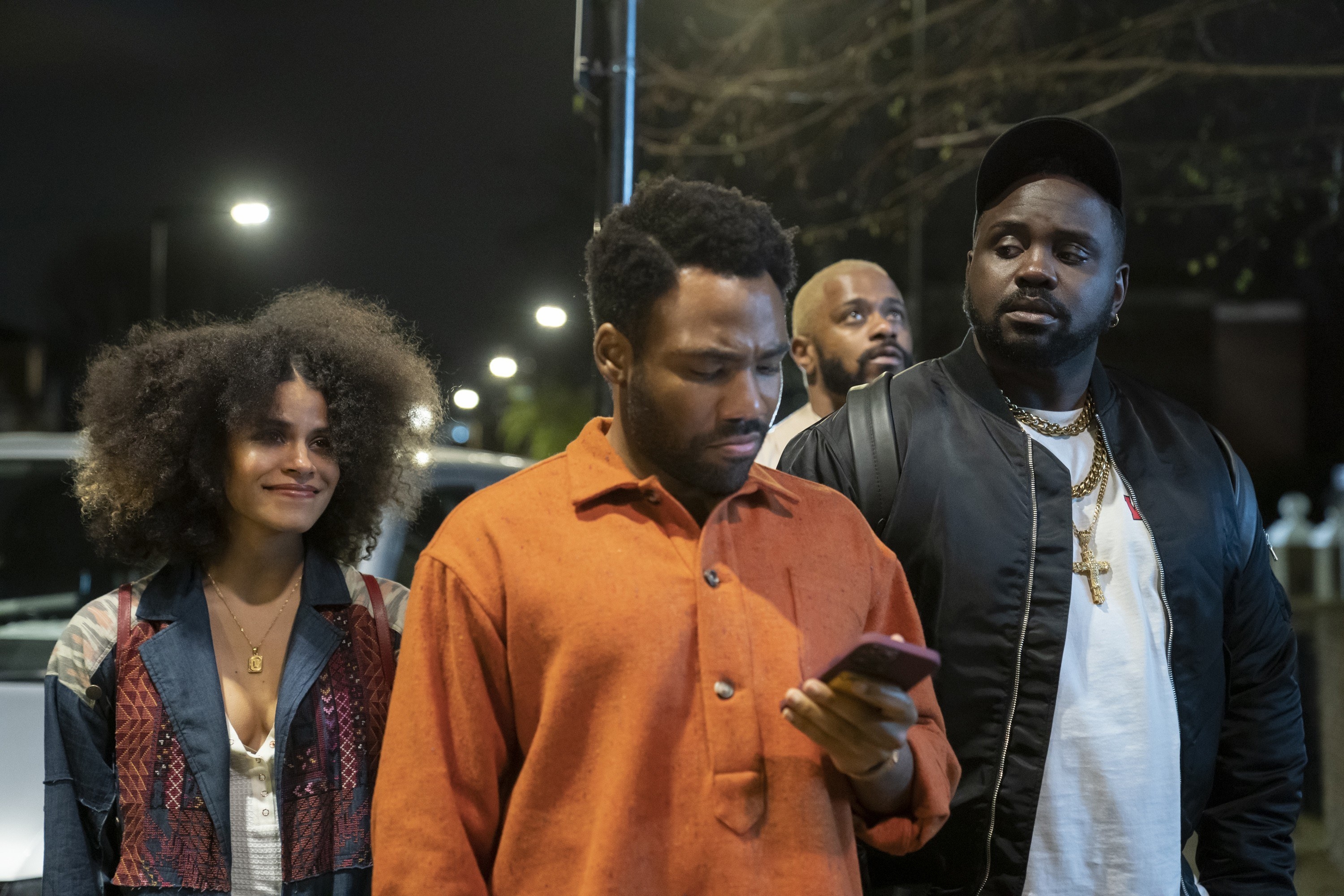 Brian walking with his costars in a scene from the show Atlanta