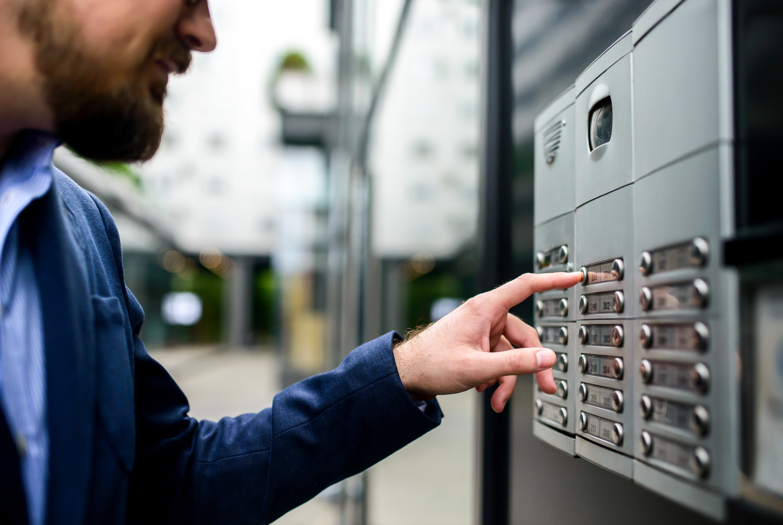 A man pushing buttons to access an apartment