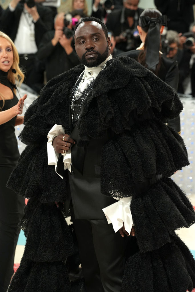 closeup of brian in his ruffled cape and many necklaces