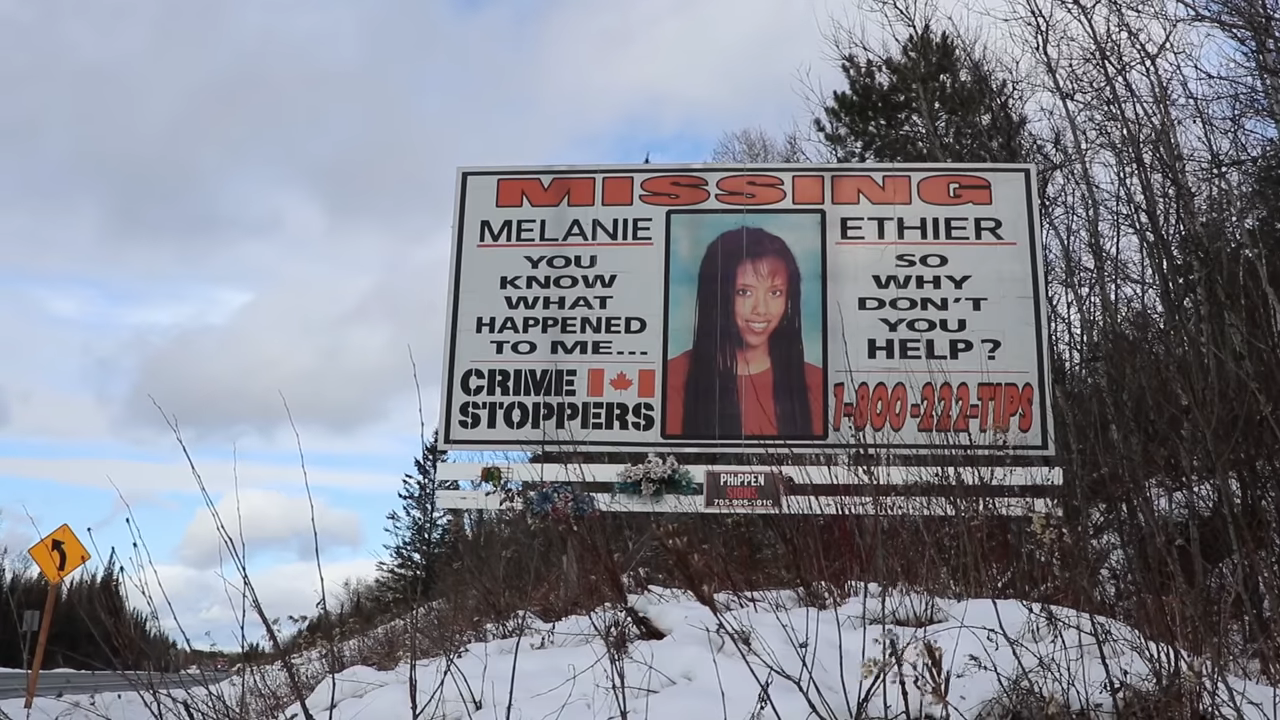 Missing person sign with a photo of Melanie by the side of the road
