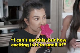 Kourtney Kardashian sitting in her kitchen smelling a pink donut, with the caption 'I can't eat this but how exciting is it to smell it?'