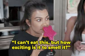 Kourtney Kardashian sitting in her kitchen smelling a pink donut, with the caption 'I can't eat this but how exciting is it to smell it?'