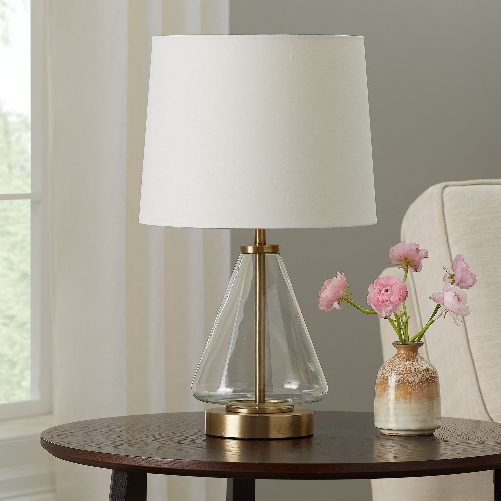 the lamp with a brass and glass base on a side table