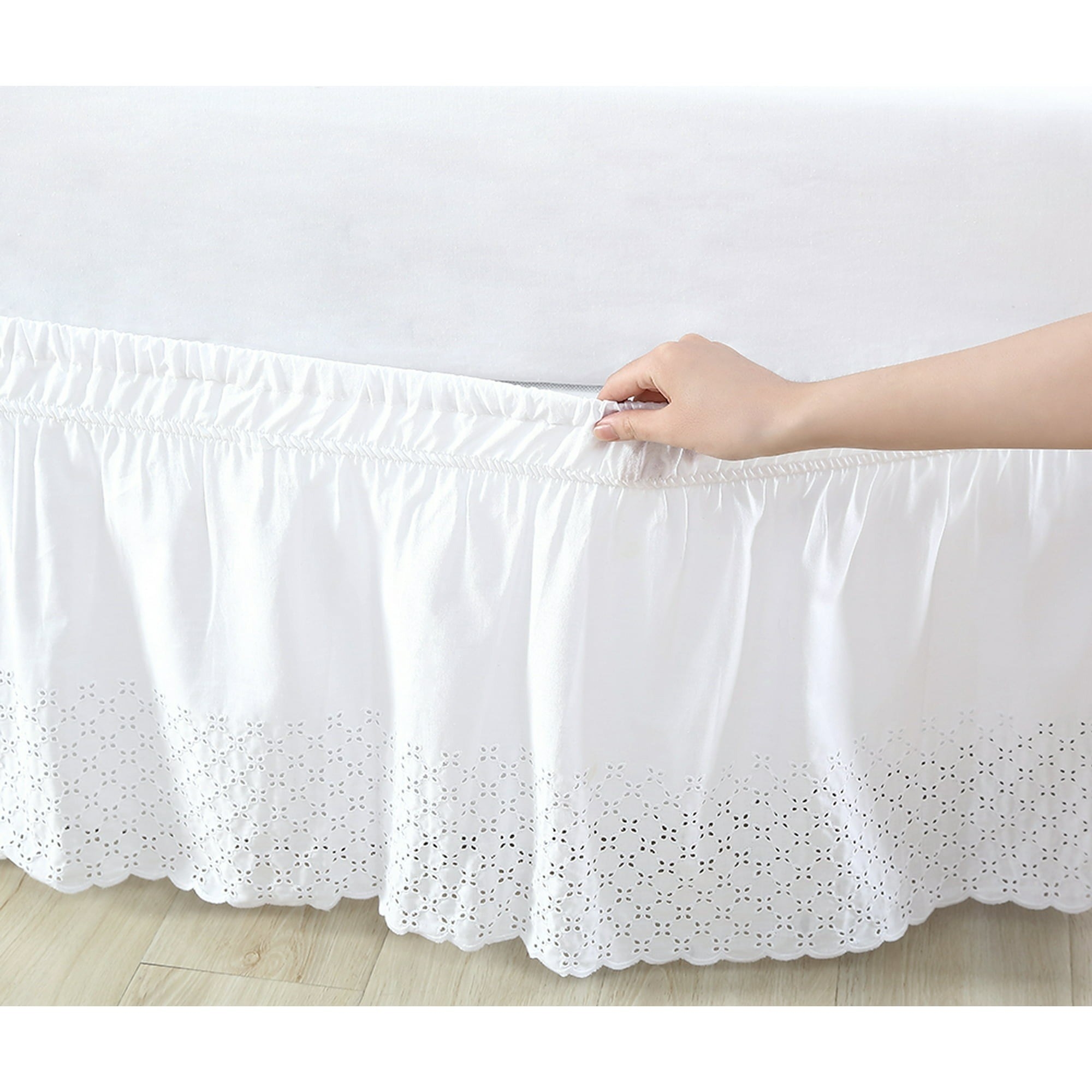 the bed skirt with an eyelet pattern on the bottom around a bed