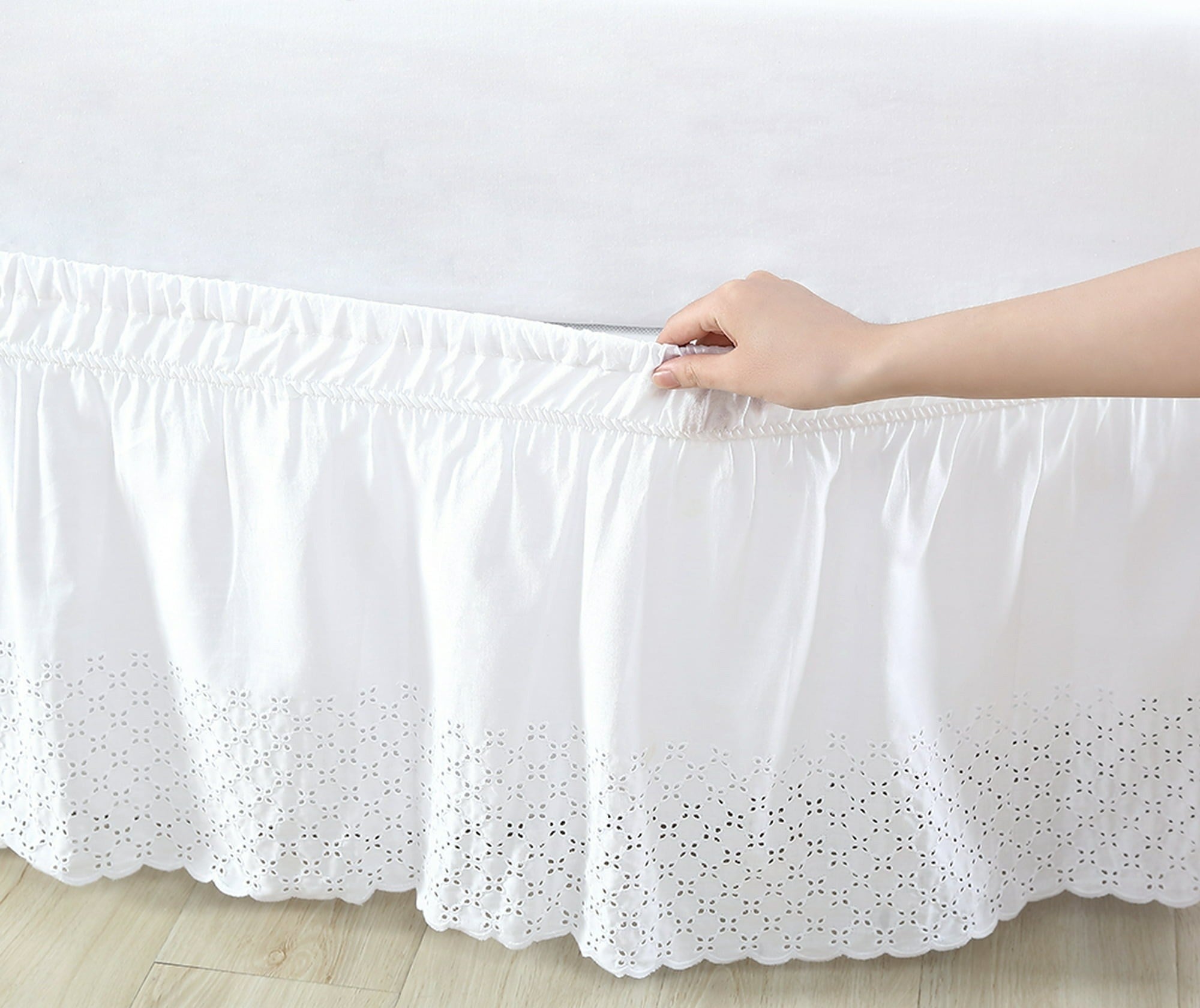 the bed skirt with an eyelet pattern on the bottom around a bed