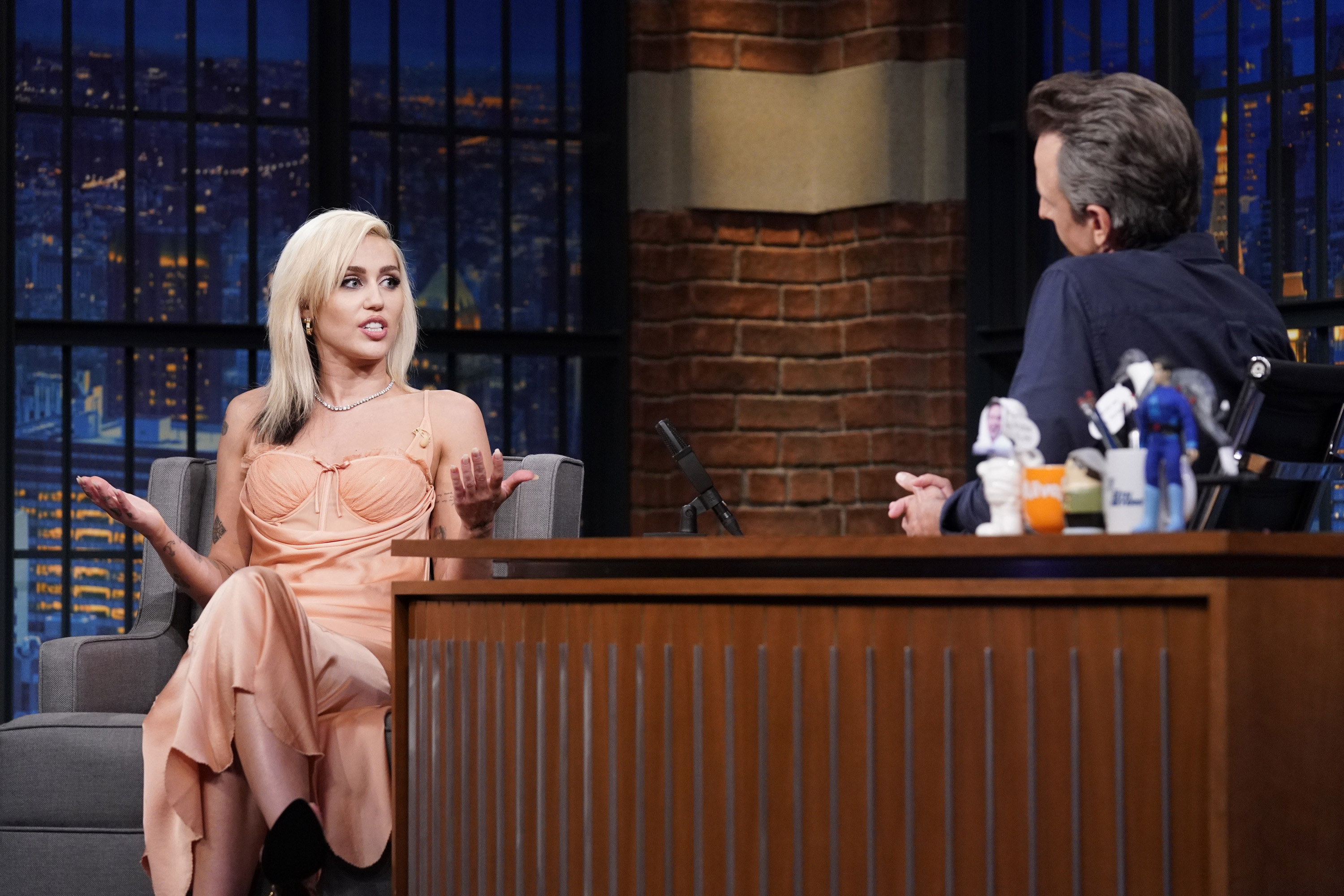 Miley Cyrus being interviewed by Seth Meyers