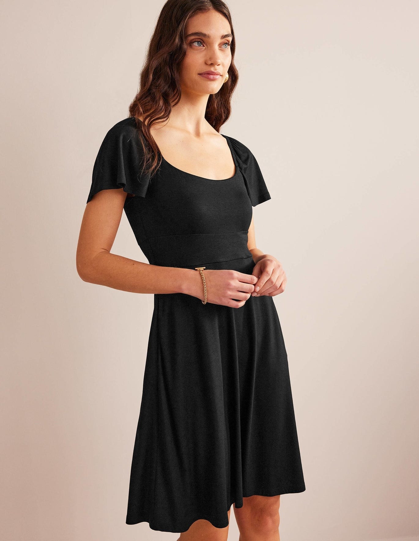 model in black square-neck knee-length a-line dress with fluttery short sleeves