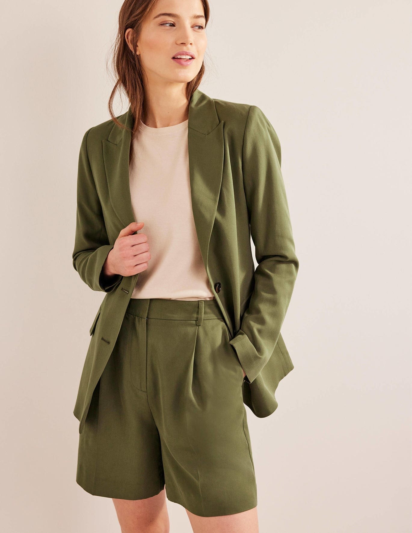 model in olive green relaxed dress shorts with a matching blazer