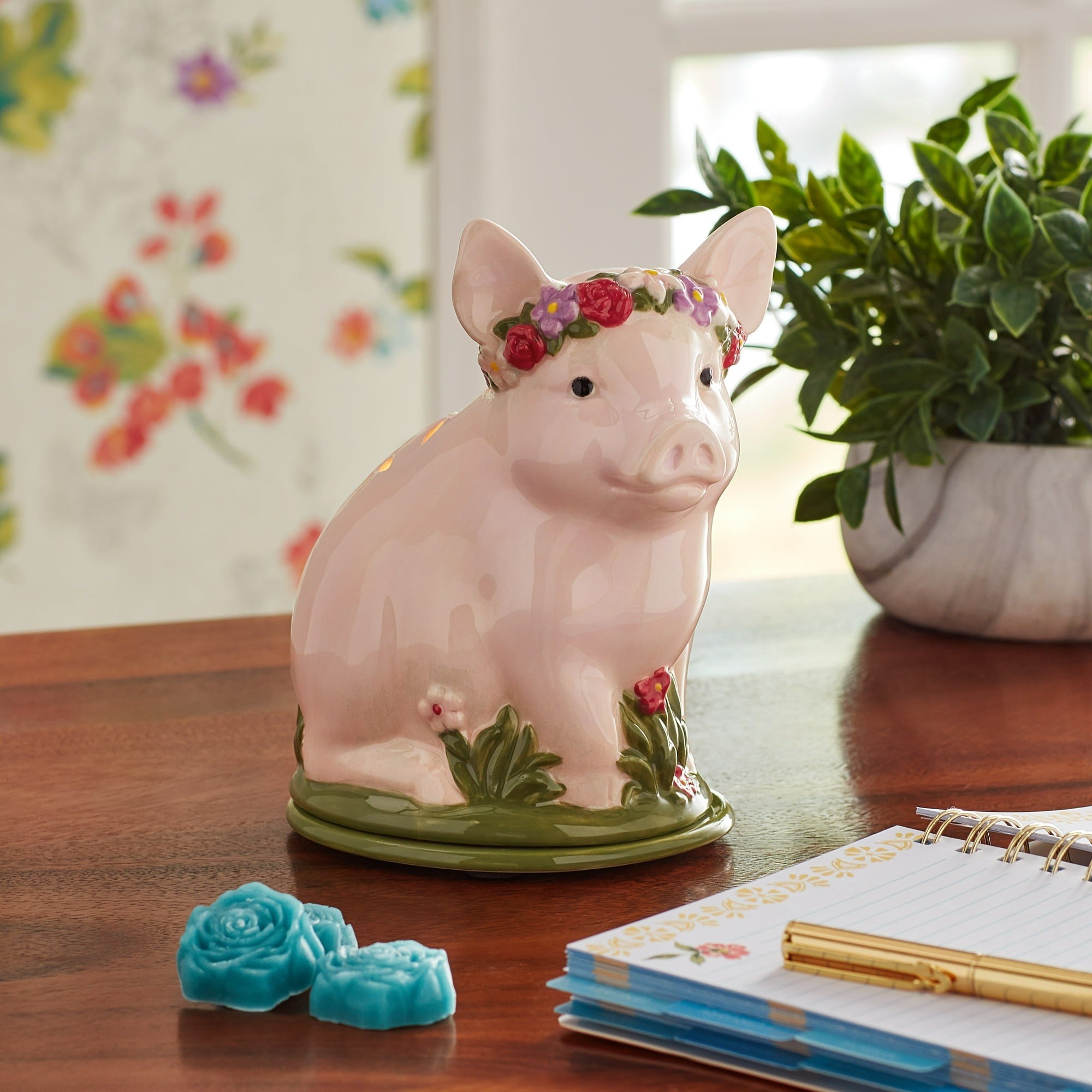 the pig fragrance warmer with a flower crown on a table