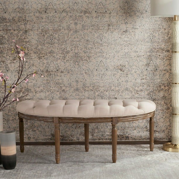 the semi-circle bench with wooden legs and a tufted cushion against a wall