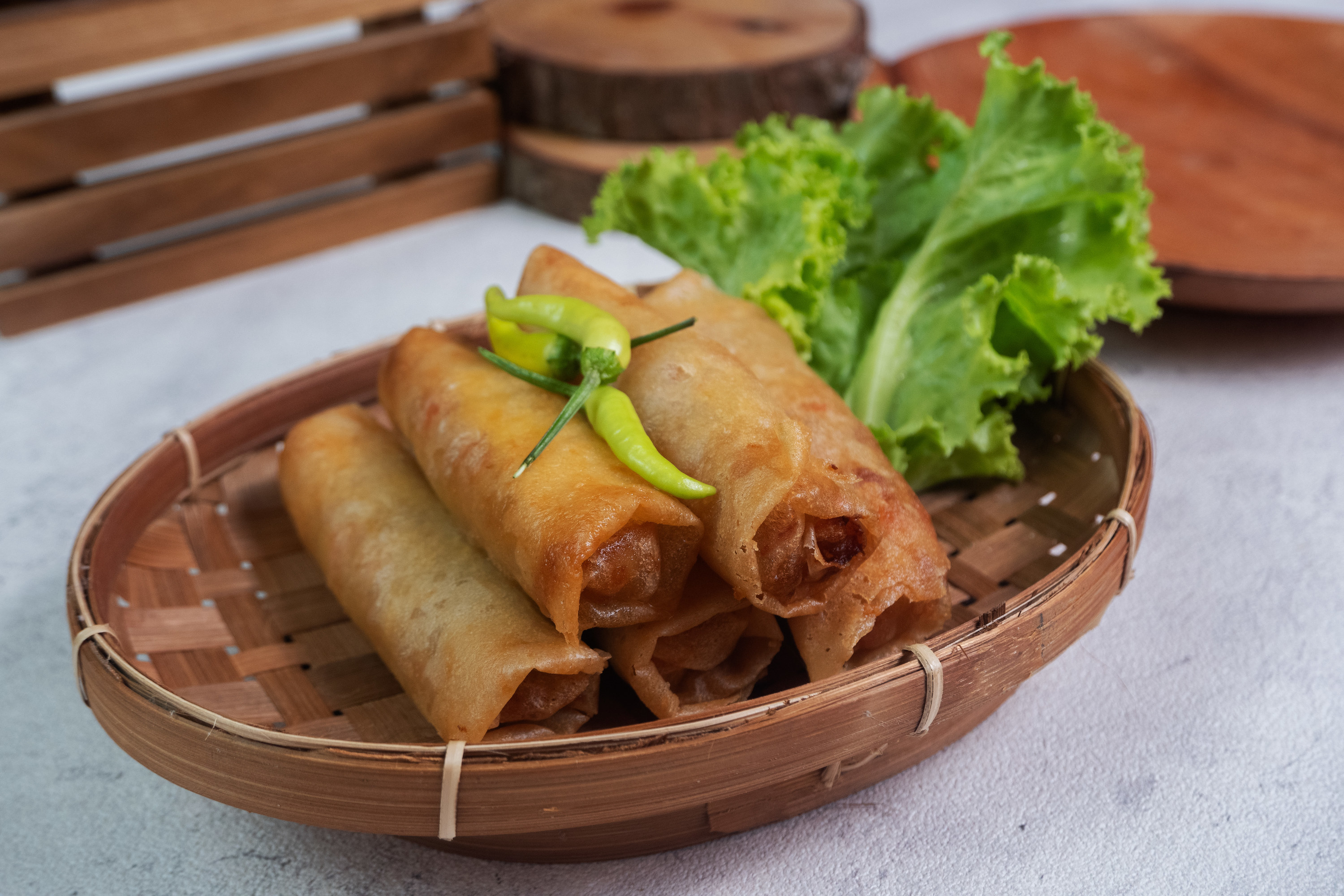 traditional spring rolls in basket next to lettuce as garnish