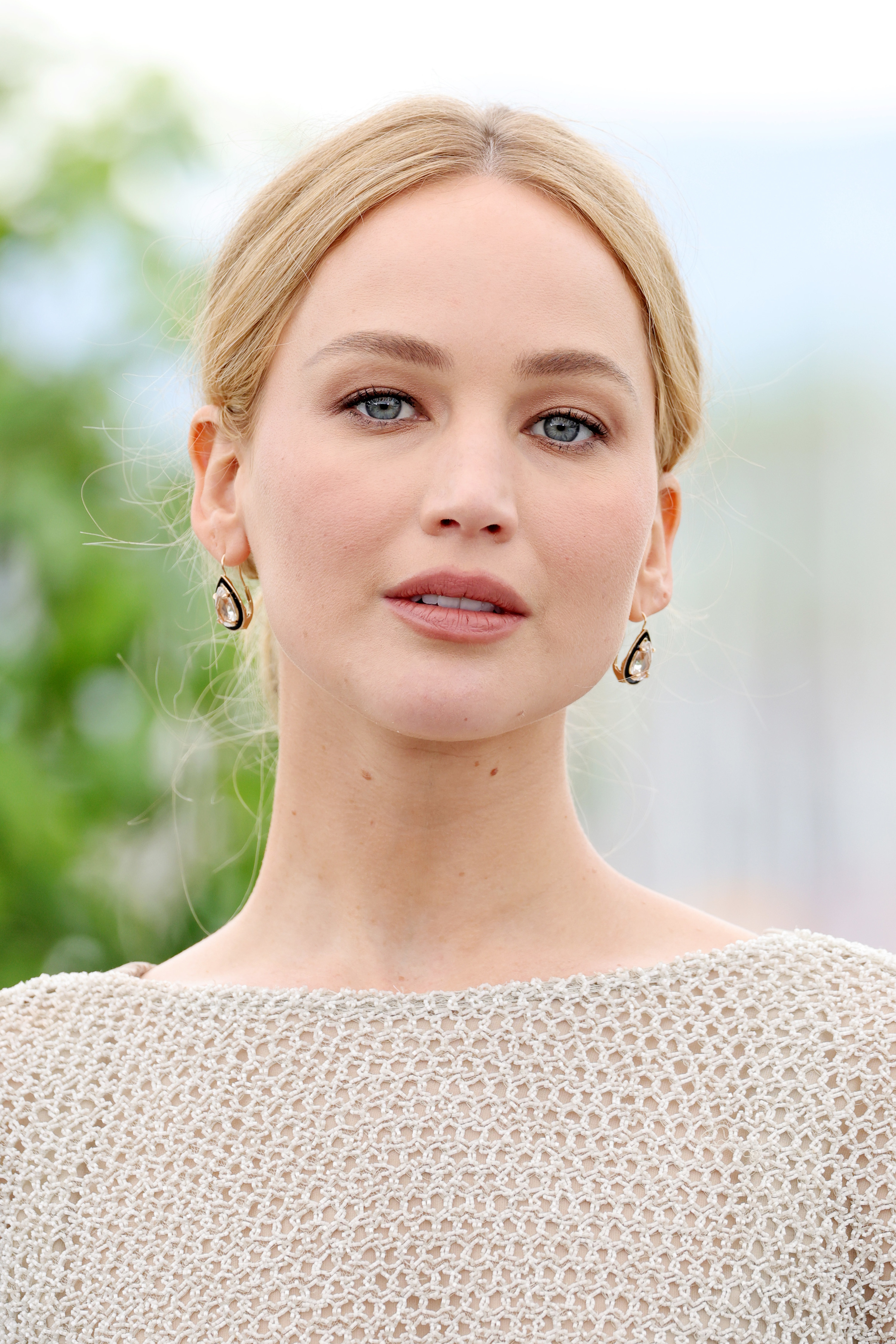 Close-up of JLaw in a sleeveless silver-gray boat-neck gown