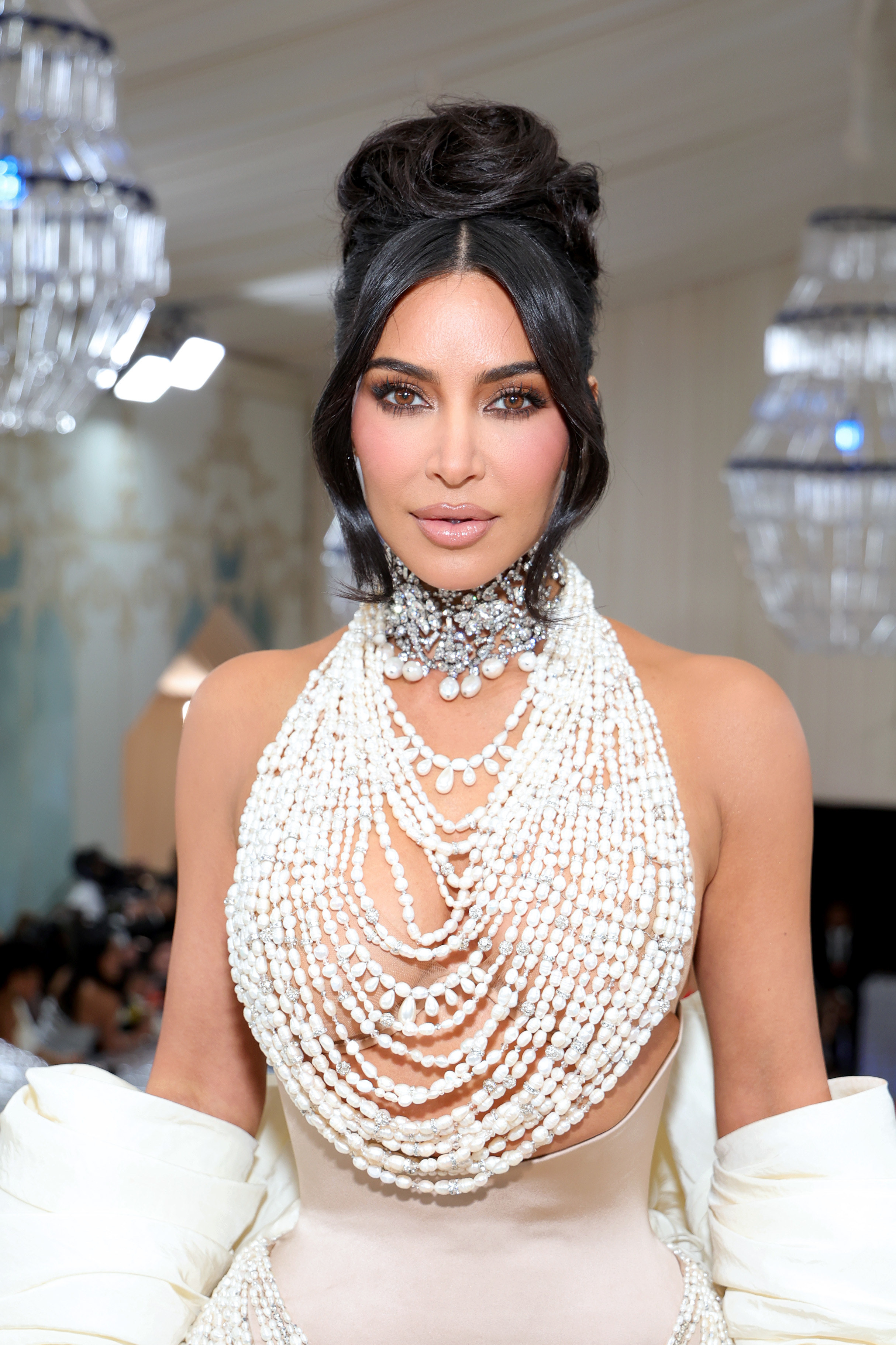 Kim in an ornate, multistrand pearl necklace that doubles at the top part of her dress