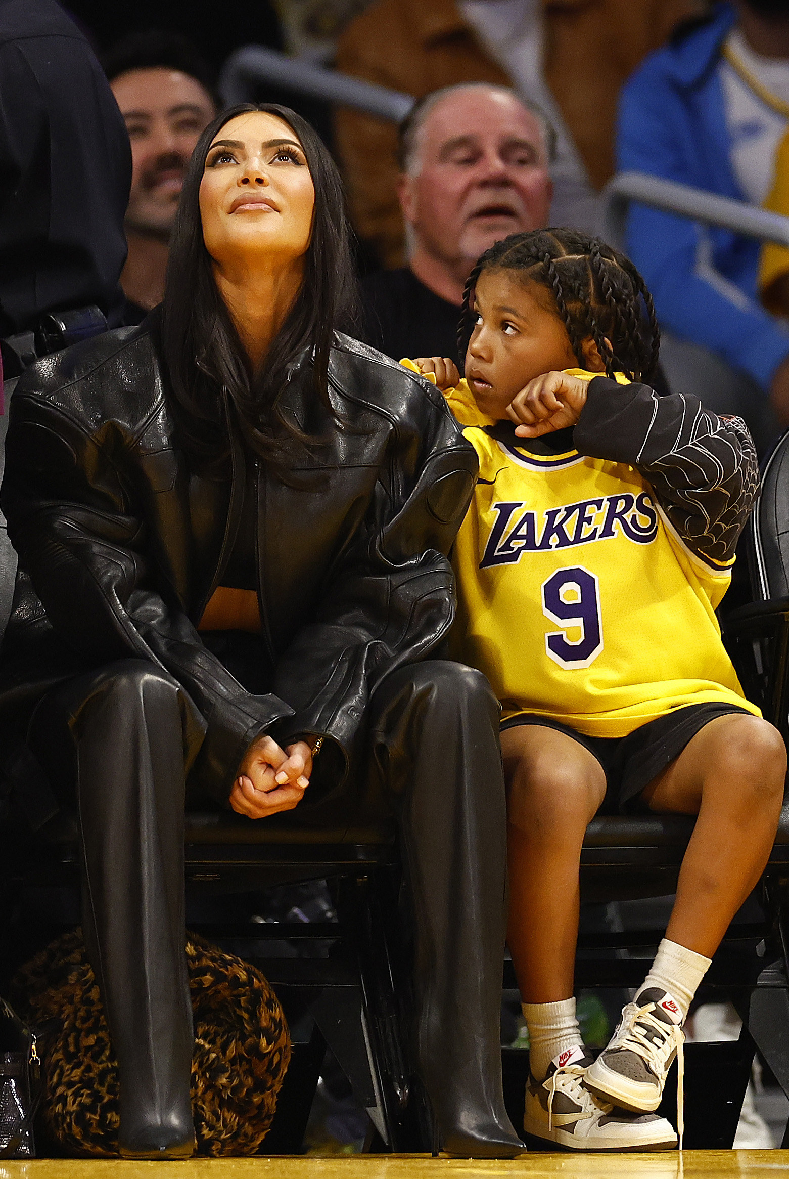 Kim sitting at a basketball game with Saint, who&#x27;s wearing a Lakers jersey