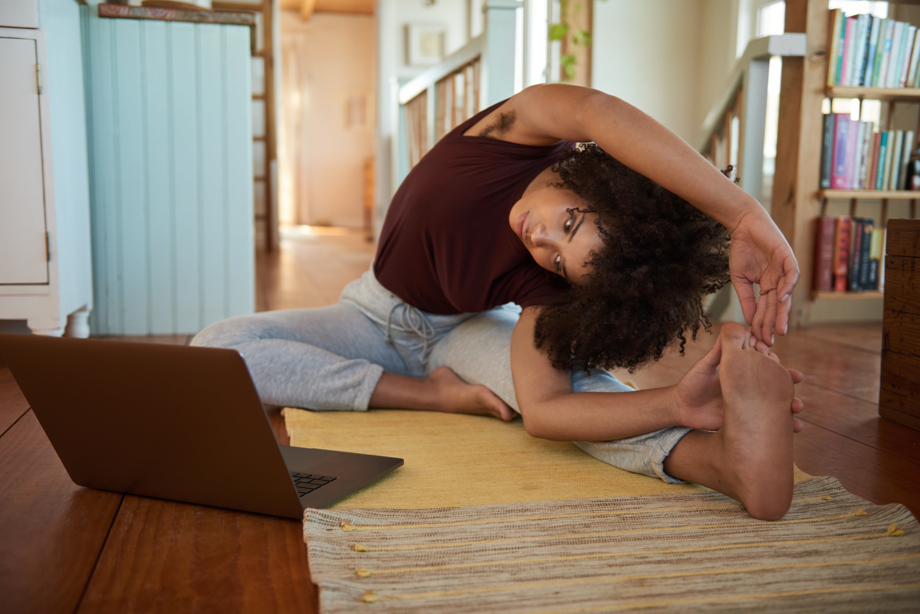 a woman doing yoga in front of computer