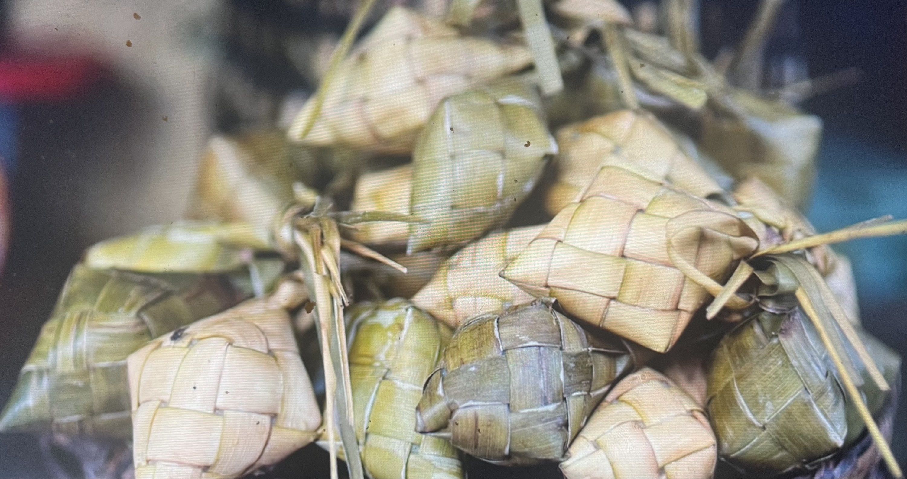 Small rice packets wrapped in woven coconut leaves