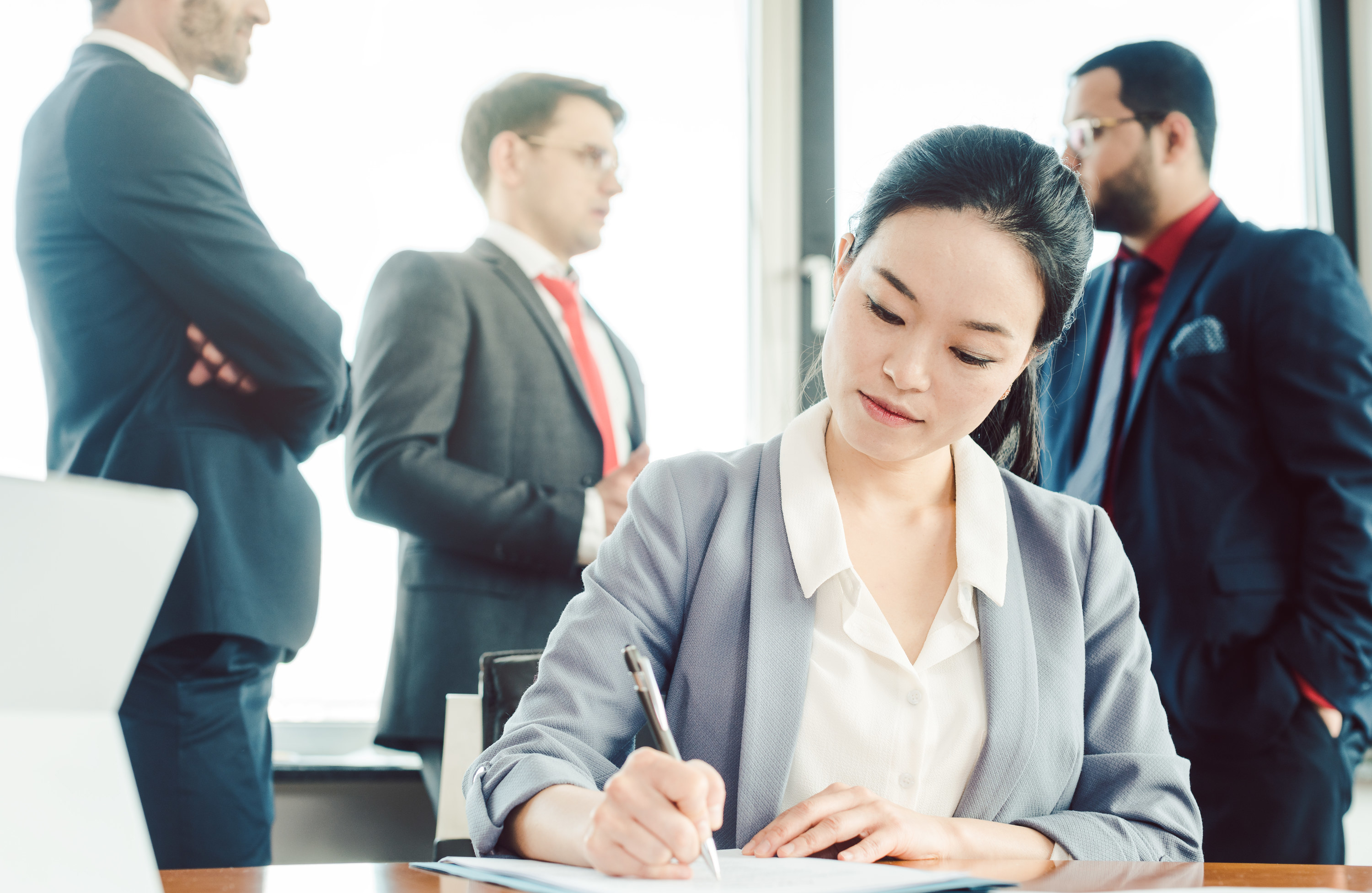 a woman doing work with men behind her