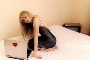 Sabrina on a bed with a laptop.