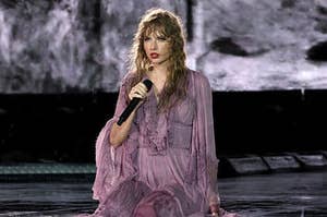 taylor swift sits in a wet dress on the stage at her "eras tour"