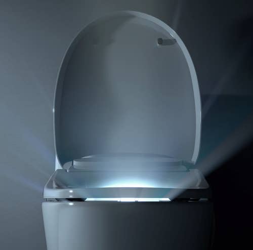 closeup of toilet seat with glowing light inside bowl