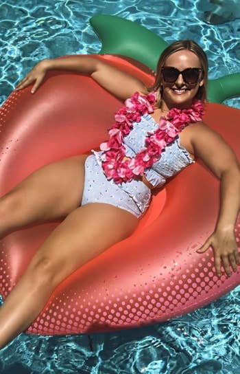 A reviewer connected a floaty wearing the airy bluish and daisies swimsuit