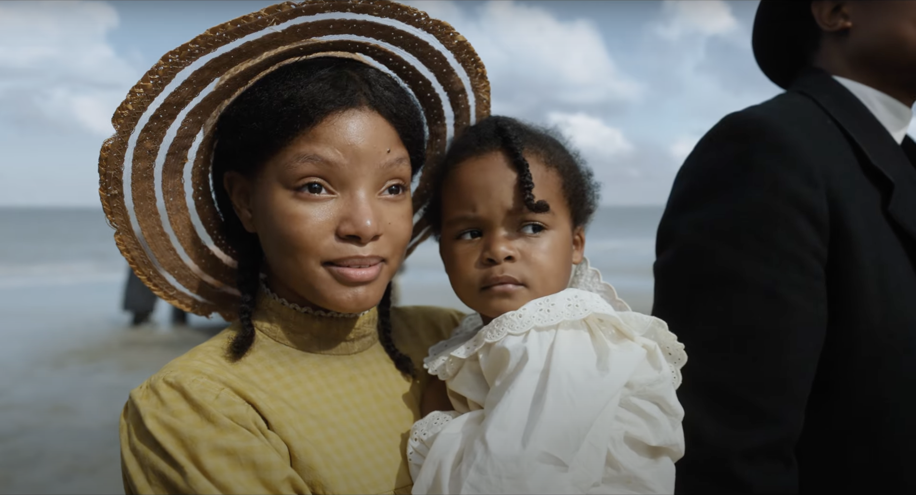 halle bailey in a still from the color purple movie holding a young child