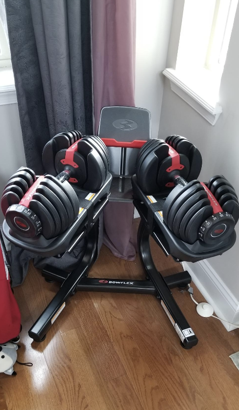A set of Bowflex adjustable weights on a weight rack