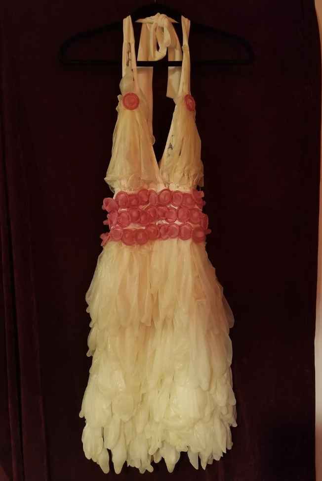 A longer halter minidress with belt made out of hanging condoms